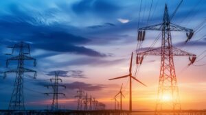Power line towers with wind turbines in the background, highlighting the integration of renewable energy sources into the electrical grid.